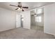 A carpeted bedroom with mirrored closet doors and a ceiling fan at 17254 W Marshall Ln, Surprise, AZ 85388
