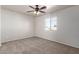 A sunlit carpeted bedroom with a ceiling fan and a window at 17254 W Marshall Ln, Surprise, AZ 85388