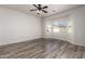 Bedroom with wood-look floors, a ceiling fan, and a view of the surrounding neighborhood at 17254 W Marshall Ln, Surprise, AZ 85388