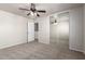 A carpeted bedroom with mirrored closet doors and a ceiling fan at 17254 W Marshall Ln, Surprise, AZ 85388