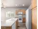 Kitchen with wood cabinets, white appliances, island with sink, and ample natural light at 17254 W Marshall Ln, Surprise, AZ 85388