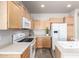 Bright kitchen features wooden cabinetry, white appliances, and a lovely decorative plant at 17254 W Marshall Ln, Surprise, AZ 85388