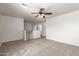Spacious loft area featuring plush carpet, a ceiling fan, and access to upstairs rooms at 17254 W Marshall Ln, Surprise, AZ 85388