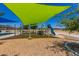 Playground featuring a green shade structure and play equipment with mulch base for safety at 17254 W Marshall Ln, Surprise, AZ 85388