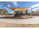 Community playground featuring covered play structure, slide and climbing area, set on a sand base with surrounding walkway at 17254 W Marshall Ln, Surprise, AZ 85388
