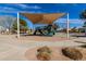 Community playground featuring covered play structure, slide and climbing area set on a sand base with surrounding walkways at 17254 W Marshall Ln, Surprise, AZ 85388