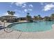 Community pool surrounded by palm trees, lounge chairs, and shaded seating at 18490 N Tanners Way, Maricopa, AZ 85138