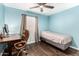 Bedroom features blue walls, hardwood floors, a ceiling fan, and a small work area at 1926 E Clarendon Ave, Phoenix, AZ 85016