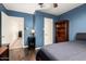 Bedroom featuring blue walls, hardwood floors, a ceiling fan, and a built-in bookcase at 1926 E Clarendon Ave, Phoenix, AZ 85016