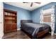 This bedroom boasts hardwood floors, blue walls, and a bookcase for stylish storage at 1926 E Clarendon Ave, Phoenix, AZ 85016