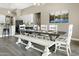 Elegant dining area with a rustic wood table, white seating, and a view of the modern kitchen at 19850 E Cattle Dr, Queen Creek, AZ 85142