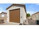 Detached garage featuring a brown door, side access gate, and exterior lighting, providing secure parking at 19850 E Cattle Dr, Queen Creek, AZ 85142