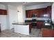 Well-lit kitchen featuring granite countertops, a center island, stainless steel appliances, and dark wood cabinetry at 20850 E Shetland St, Queen Creek, AZ 85142