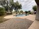 Backyard view of private swimming pool surrounded by mature trees and landscaping in fenced yard at 20850 E Shetland St, Queen Creek, AZ 85142