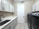 Laundry room with gray cabinets, white countertops, stainless steel sink and machines at 22360 N Daniel Dr, Maricopa, AZ 85138