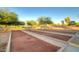 View of the bocce ball court and lounge area surrounded by mature trees offering tons of shade at 22988 W Twilight Trl, Buckeye, AZ 85326