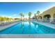Community pool with lounge chairs, and beautiful palm trees at 22988 W Twilight Trl, Buckeye, AZ 85326