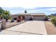 Single story home with desert landscaping, an arched front entryway and a two-car garage at 2301 E Christy Dr, Phoenix, AZ 85028