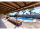 Backyard view of a sparkling pool surrounded by desert landscaping and shaded by a covered patio at 2301 E Christy Dr, Phoenix, AZ 85028