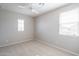 Empty bedroom with neutral carpet and two windows, offering ample space and natural light at 23764 N 162Nd Ave, Surprise, AZ 85387