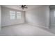 Bright, empty bedroom with neutral carpet, a ceiling fan, and windows for natural light at 23764 N 162Nd Ave, Surprise, AZ 85387