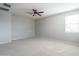 Empty bedroom with neutral carpet, a ceiling fan, and ample light from the window at 23764 N 162Nd Ave, Surprise, AZ 85387