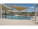 A tranquil community pool offers a refreshing retreat with ample seating and shade features at 23764 N 162Nd Ave, Surprise, AZ 85387