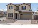 Inviting two-story home with stone accents, a brown tiled roof, and a two-car garage at 23764 N 162Nd Ave, Surprise, AZ 85387