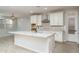 Open-concept kitchen with white cabinets, granite countertops, and a large island with a sink at 23764 N 162Nd Ave, Surprise, AZ 85387