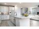 Bright modern kitchen features white cabinets, stainless steel appliances, and a large island with granite countertops at 23764 N 162Nd Ave, Surprise, AZ 85387