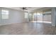 Spacious, light-filled living room with wood-look tile floors and sliding glass doors to the outdoor area at 23764 N 162Nd Ave, Surprise, AZ 85387