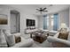 Living room with cozy white seating, a large TV, and plenty of natural light from the windows at 23764 N 162Nd Ave, Surprise, AZ 85387