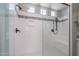 Shower with glass enclosure, featuring black fixtures, white tile, and a built-in bench at 23764 N 162Nd Ave, Surprise, AZ 85387