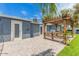 Backyard view featuring a pergola-covered patio area with seating, well-maintained landscaping and patio doors at 2441 E Edgemont Ave, Phoenix, AZ 85008
