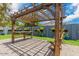 The private backyard offers a pergola-covered patio area, green lawn and unique wall decor at 2441 E Edgemont Ave, Phoenix, AZ 85008