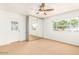 Bright bedroom with mirrored closet, ceiling fan, neutral carpet and an exterior door with window at 2441 E Edgemont Ave, Phoenix, AZ 85008