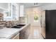 Modern kitchen with stainless steel appliances, mosaic backsplash, double sink, and stylish cabinets at 2441 E Edgemont Ave, Phoenix, AZ 85008