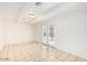 Bright living area with white walls, beamed ceilings, and tile flooring leading to glass patio doors at 2441 E Edgemont Ave, Phoenix, AZ 85008