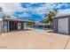 A backyard view showcases a sparkling pool, covered patio, and lush palm trees on a sunny day at 2441 E Edgemont Ave, Phoenix, AZ 85008