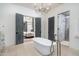 Bright bathroom features a standalone tub, walk-in shower, and direct access to the bedroom through gray paneled doors at 27914 N 100Th Pl, Scottsdale, AZ 85262