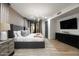 Comfortable bedroom with king bed, neutral colors, stylish chandelier, and black door leading to the backyard at 27914 N 100Th Pl, Scottsdale, AZ 85262