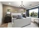 Beautiful bedroom with a large window, a chandelier, and three smaller windows on the wall at 27914 N 100Th Pl, Scottsdale, AZ 85262
