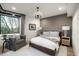 Relaxing bedroom featuring a king bed, sitting area, stylish chandelier, and black framed window overlooking greenery at 27914 N 100Th Pl, Scottsdale, AZ 85262