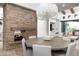 Dining room with stone fireplace, modern chandelier, and round table with seating for six at 27914 N 100Th Pl, Scottsdale, AZ 85262