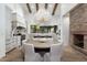 Gourmet kitchen with a large dining table, stone fireplace, and modern chandelier at 27914 N 100Th Pl, Scottsdale, AZ 85262