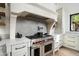 Close up on a professional-grade range and oven, complete with custom cabinetry at 27914 N 100Th Pl, Scottsdale, AZ 85262