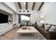 Comfortable living room with beamed ceilings, built-in shelving, and a large window with views of the natural desert landscape at 27914 N 100Th Pl, Scottsdale, AZ 85262