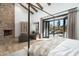 Bright main bedroom with a stone fireplace and doors opening onto the patio at 27914 N 100Th Pl, Scottsdale, AZ 85262