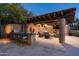 Outdoor kitchen with bar seating, stone pillars, a shaded lounge area with comfortable seating at 27914 N 100Th Pl, Scottsdale, AZ 85262