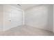A simple bedroom featuring white walls, carpet floors, and closet with white sliding doors at 31672 N 135Th Ln, Peoria, AZ 85383